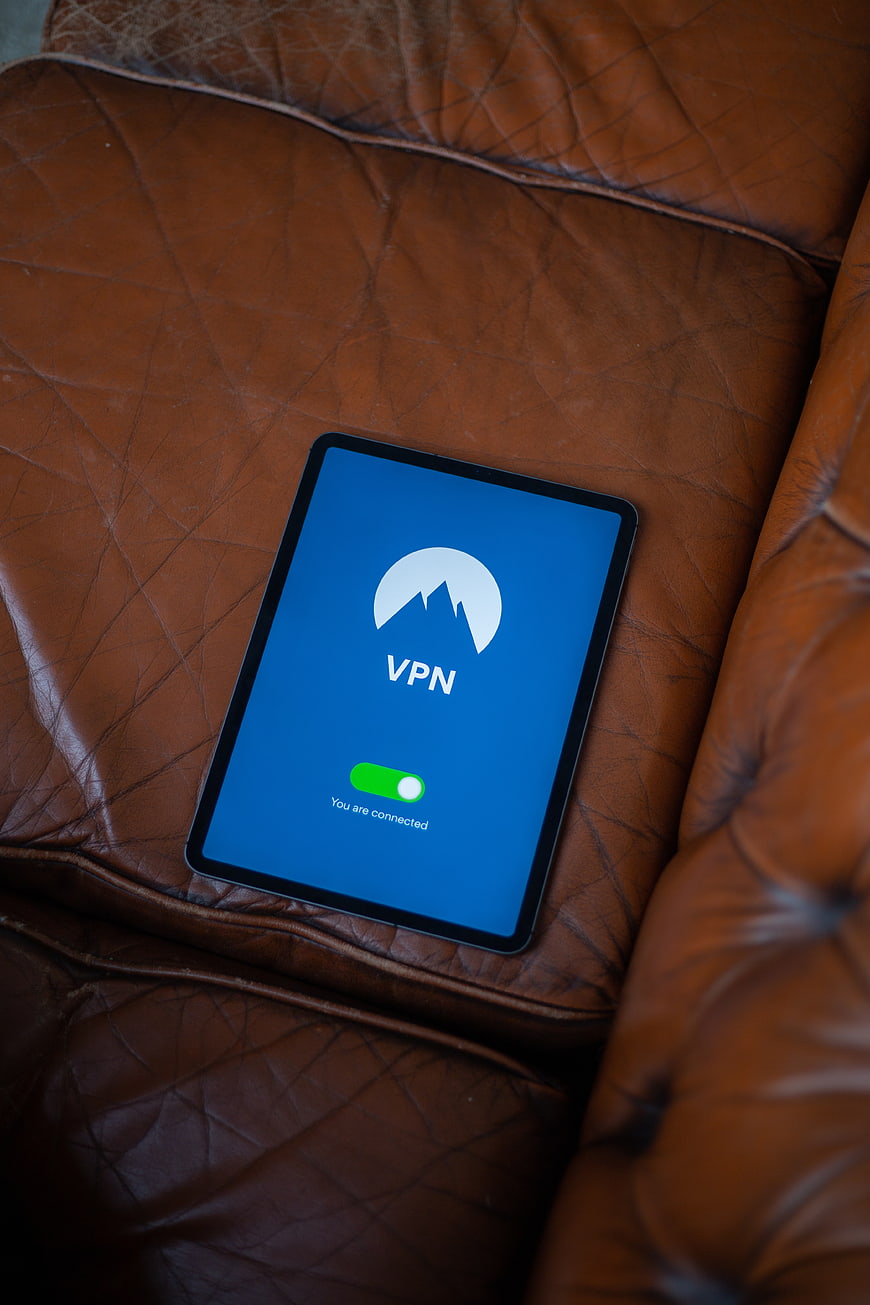 Tablet with VPN app on brown leather sofa
