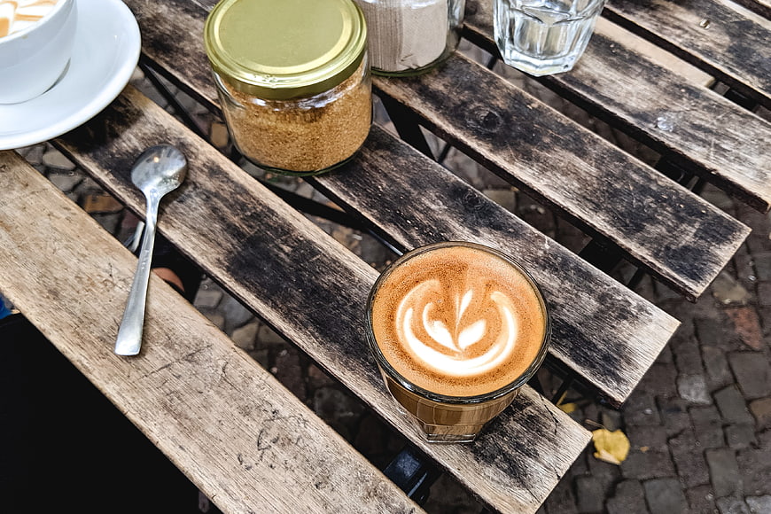 Overhead view of cappuccino with latte art on rustic wooden table