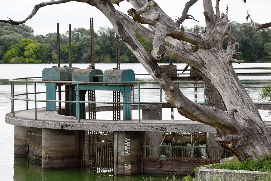 Weathered Concrete Dam Structure With Dead Tree And Rusty Metal