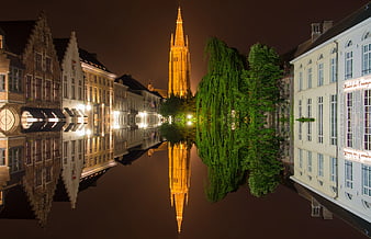 Upside-down night view of Bruges canal and church tower