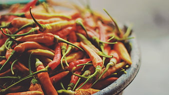 Close-up of fresh red and green chili peppers in a bowl