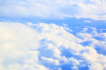 Fluffy white clouds against a bright blue sky background