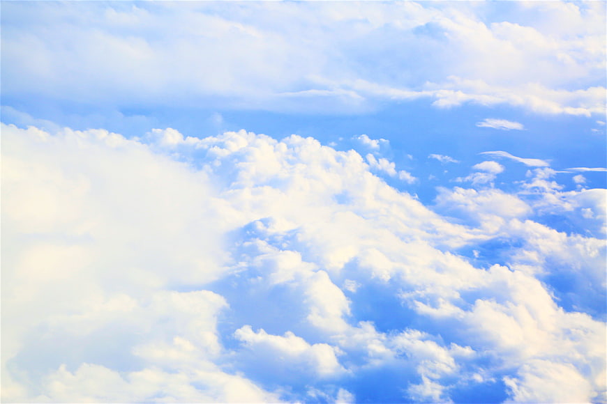 Fluffy white clouds against a bright blue sky background