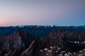 Majestic Mountain Range at Twilight with Snowy Peaks