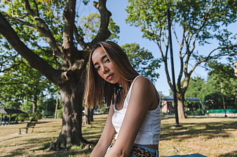 Young woman sitting on park bench in summer
