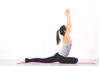Woman doing yoga lunge stretch on pink mat