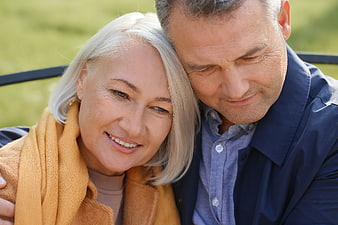 Senior couple embracing outdoors in affectionate portrait