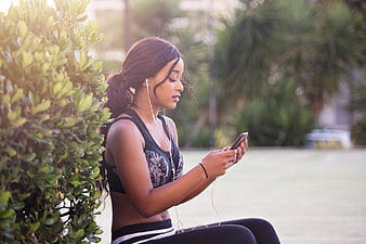 Woman in Sportswear Listening to Music on Smartphone