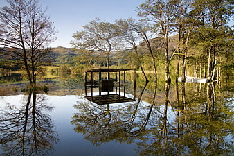 Wooden Cabin Floating on Calm Loch in Scottish Highlands