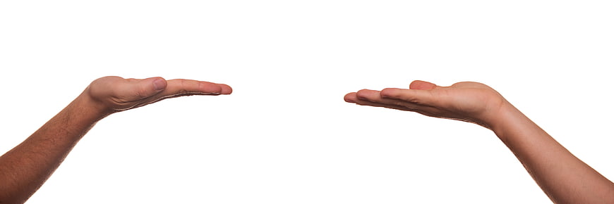 Two Open Hands Reaching Toward Each Other On White Background