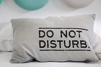 Gray Do Not Disturb Pillow on White Bed
