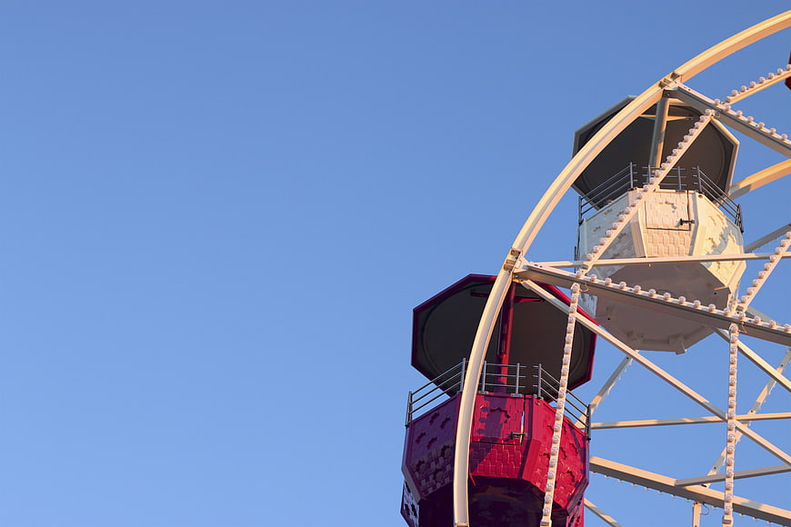 Ferris Wheel Coaches Against Blue Sky