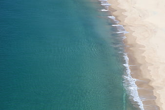 Aerial View of Turquoise Ocean Waves Meeting Sandy Beach