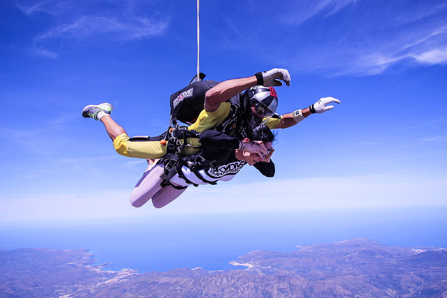 Tandem Skydiving Freefall Over Coastal Landscape