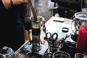 Barista Brewing Coffee with AeroPress in Cafe