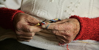 Close-up of elderly hands crocheting with colorful yarn