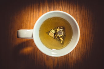 Top View of Herbal Tea Bag in White Mug on Wood