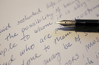 Close-up of fountain pen tip on handwritten cursive text
