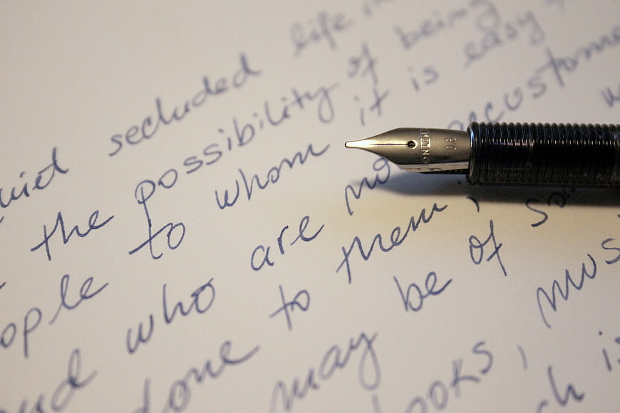 Close-up of fountain pen tip on handwritten cursive text