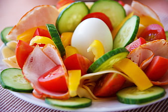 Fresh vegetable salad with ham, cheese, and boiled egg