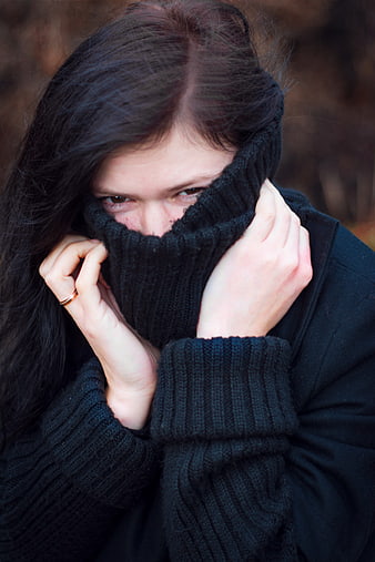 Woman Pulling Up Black Sweater Neck in Cold Weather
