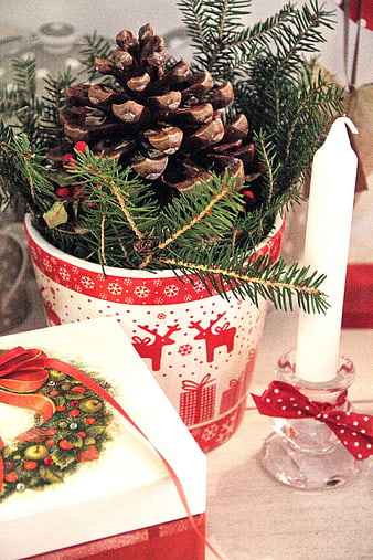 Christmas centerpiece with pine cone, candle, and gift box