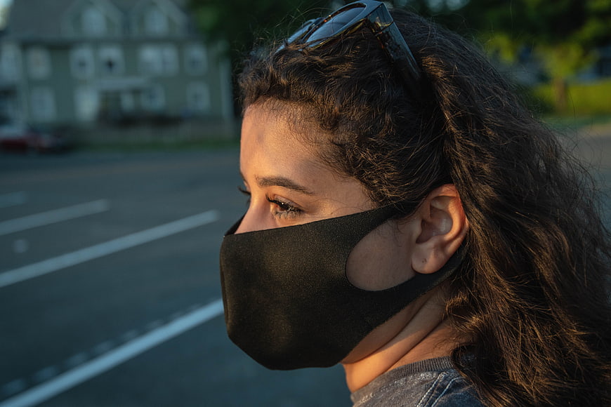 Woman Wearing Black Face Mask Outdoors at Sunset