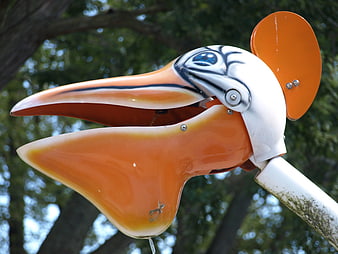 Close-up of orange pelican water fountain in park