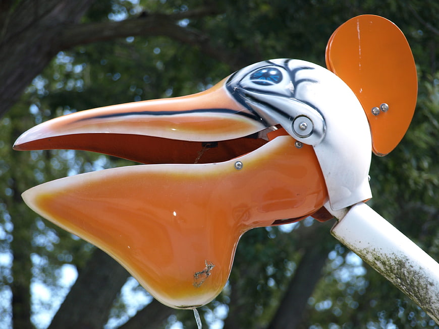 Close-up of orange pelican water fountain in park