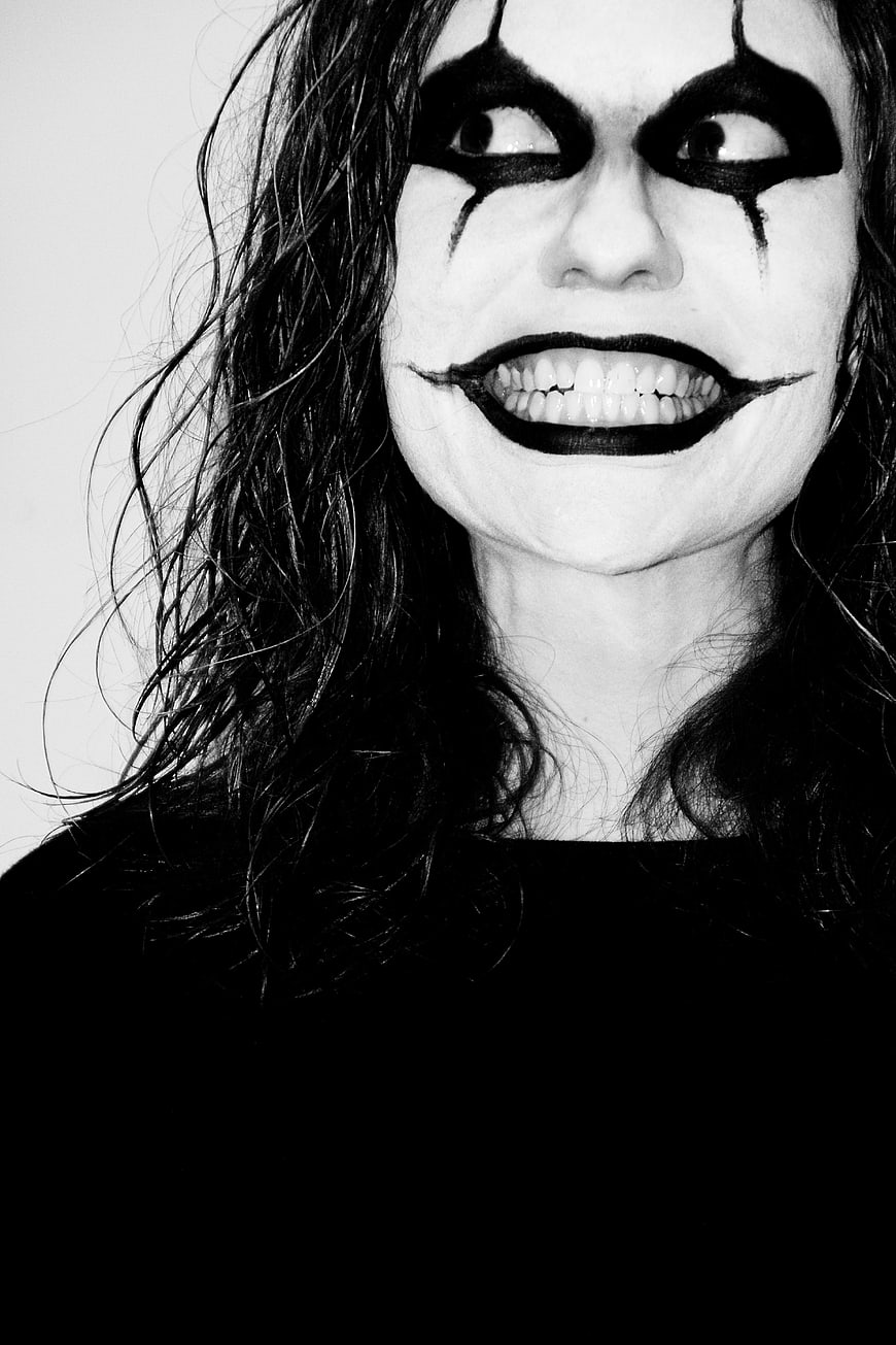 Woman with dramatic clown makeup and creepy smile