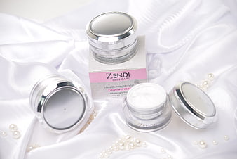 White skincare cream jars on satin with pearls