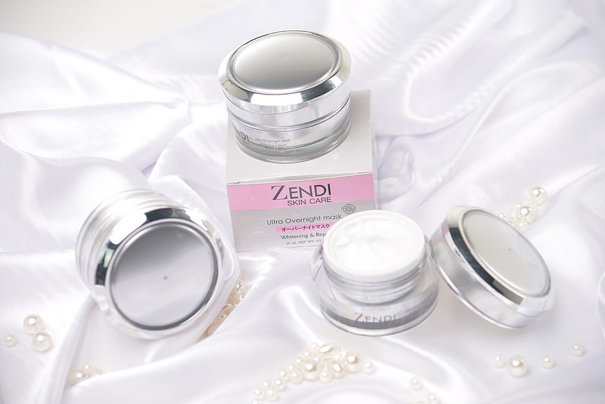 White skincare cream jars on satin with pearls
