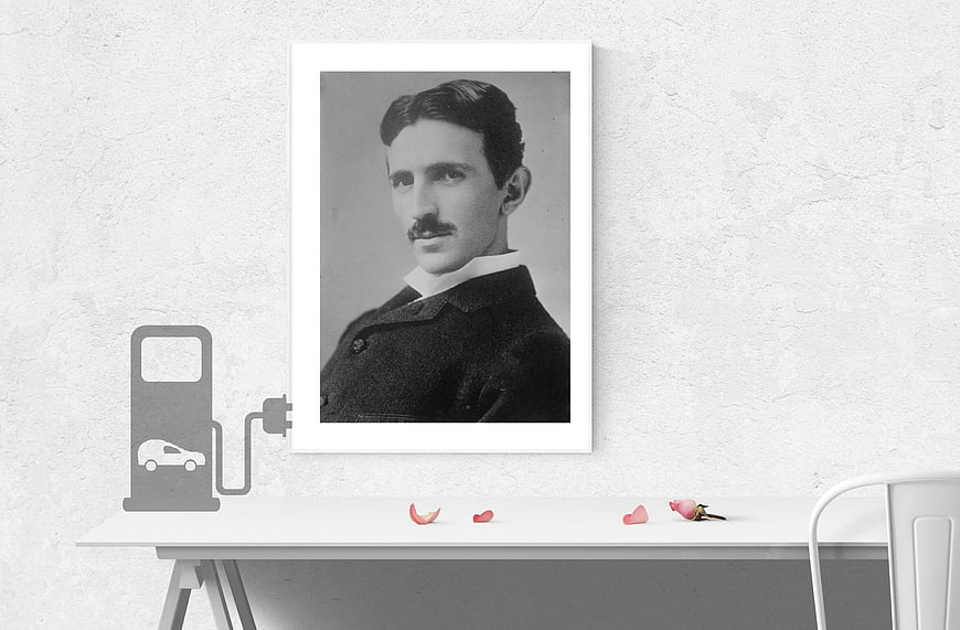 Framed Nikola Tesla Portrait On White Desk With Electric Car Charging Icon