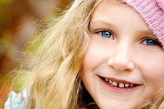 Close-up portrait of smiling blonde girl with blue eyes