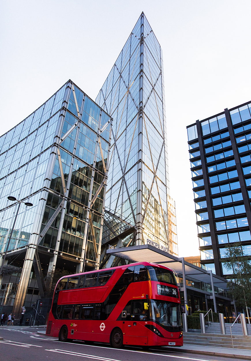 Red Double-Decker Bus in Modern London Cityscape