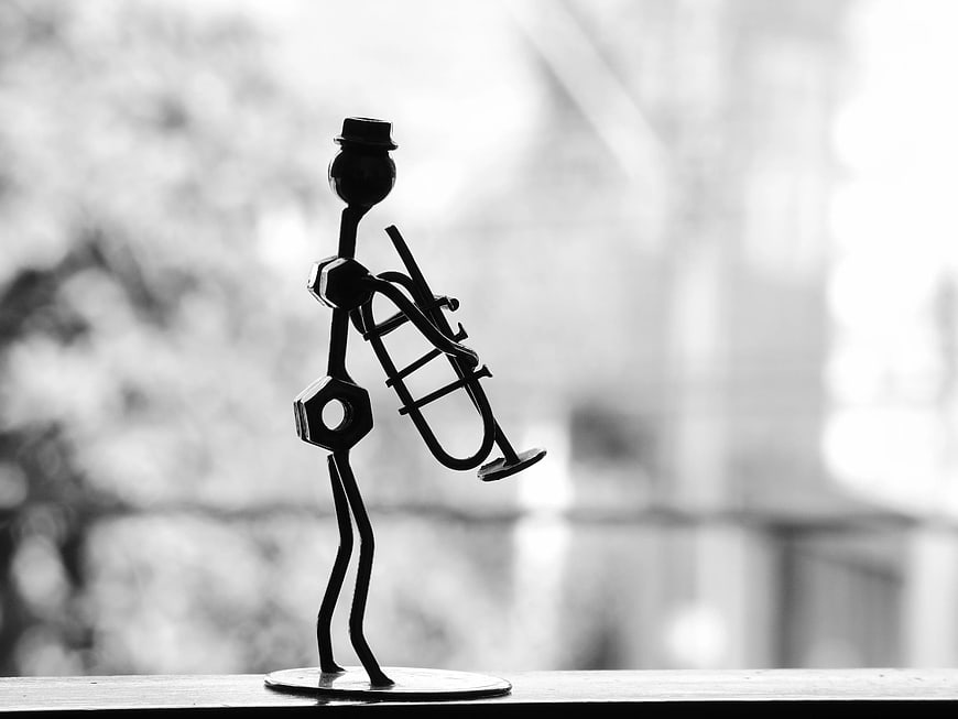 Black and white silhouette of a metal trumpet player figurine