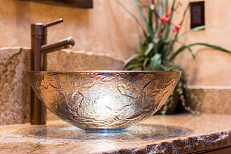 Luxurious hammered metal vessel sink in warm modern bathroom interior