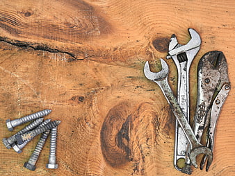 Rusty wrenches and screws on rustic wooden background