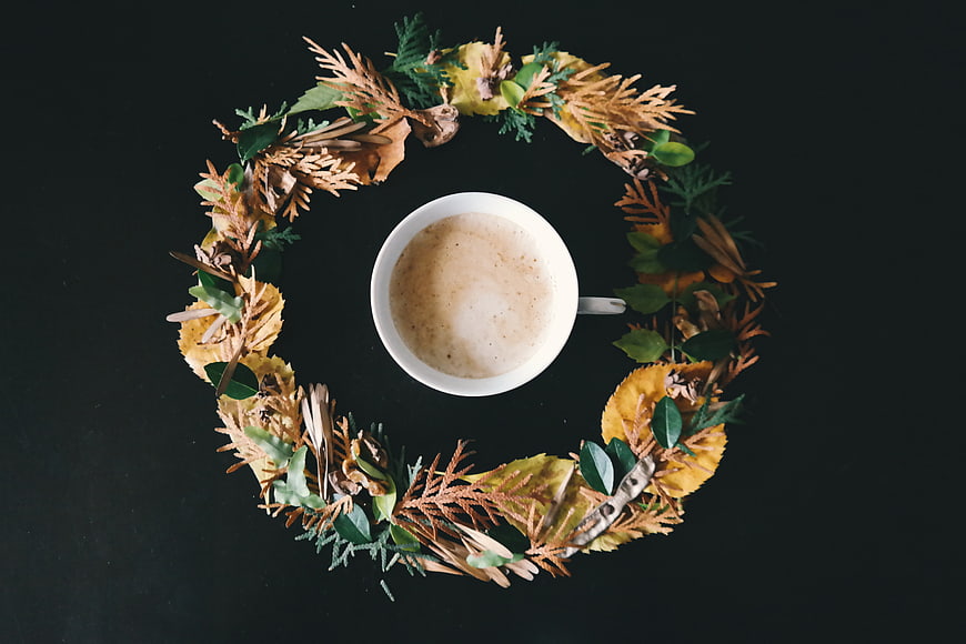 Overhead view of coffee cup in autumn wreath