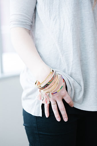 Woman wearing colorful stack of bracelets and tassel jewelry