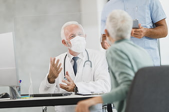 Senior Doctor Consulting with Elderly Patient in Clinic