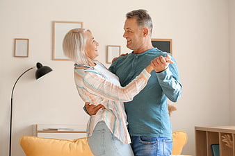 Happy Senior Couple Dancing Together in Living Room