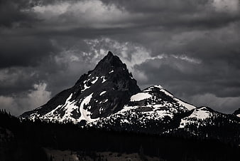 Dramatic Black and White Mountain Peak with Snow and Clouds
