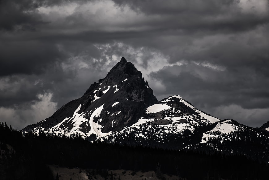 Dramatic Black and White Mountain Peak with Snow and Clouds