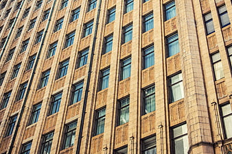 Low angle view of beige stone building facade with repeating windows