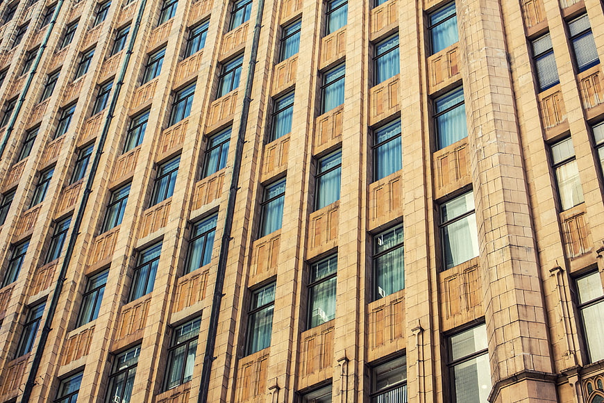Low angle view of beige stone building facade with repeating windows