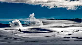 Snowy Yellowstone Landscape with Geothermal Steam and Blue Sky