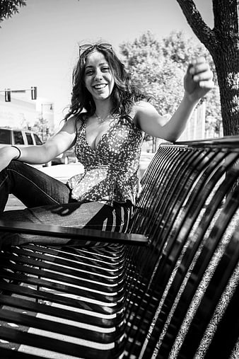 Happy Woman Sitting on Park Bench in Black and White