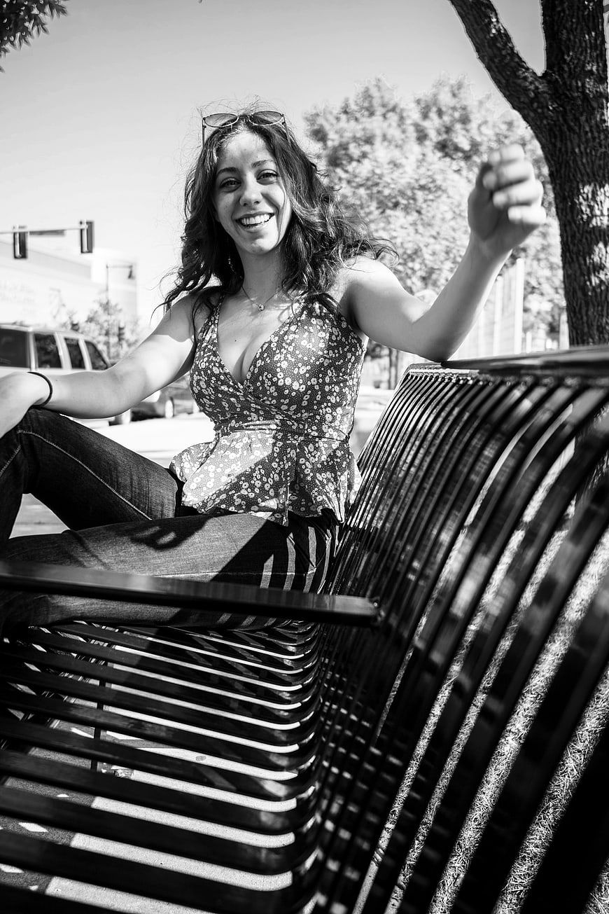 Happy Woman Sitting on Park Bench in Black and White