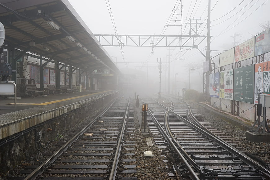 Foggy Train Station Tracks with Platform and Billboards